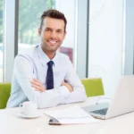 Happy man sitting at desk in the office
